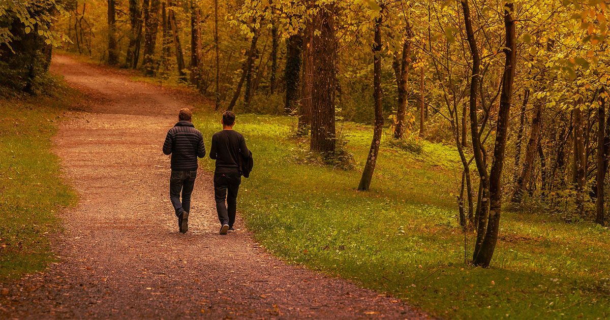 Två personer som går på en promenadväg